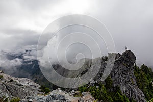 Adventurous Man Standing on top of a rugged rocky mountain