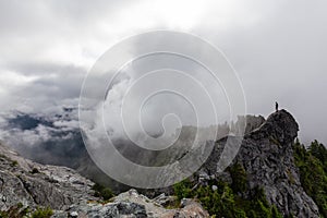 Adventurous Man Standing on top of a rugged rocky mountain