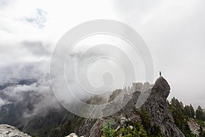 Adventurous Man Standing on top of a rugged rocky mountain