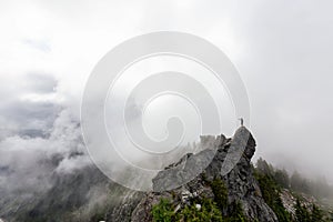 Adventurous Man Standing on top of a rugged rocky mountain