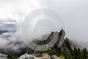 Adventurous Man Standing on top of a rugged rocky mountain