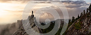 Adventurous Man on top of a rugged rocky mountain.