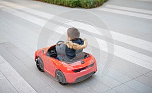 Adventurous Toddler Drives Red Sports Car with Joyful Glee