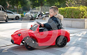 Adventurous Toddler Drives Red Sports Car with Joyful Glee