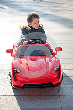 Adventurous Toddler Drives Red Sports Car with Joyful Glee