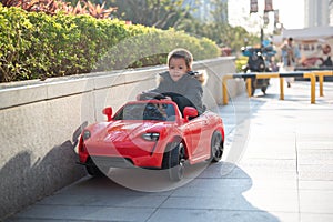 Adventurous Toddler Drives Red Sports Car with Joyful Glee