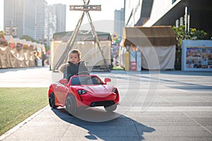 Adventurous Toddler Drives Red Sports Car with Joyful Glee