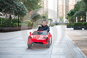 Adventurous Toddler Drives Red Sports Car with Joyful Glee