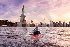 Adventurous Woman Sea Kayaking near the Statue of Liberty