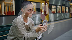 Adventurous woman waiting train looking on smartphone close up. Short hair girl