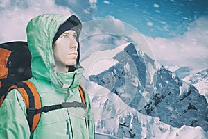 Adventurous young man with backpack standing on mountain top view and looking out. Mountaineering, extreme sport.