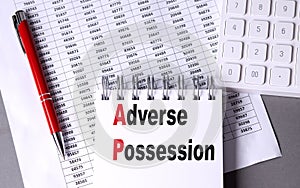 ADVERSE POSSESSION text on notebook with chart , pen and calculator photo