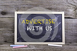 Advertise With Us. Chalk board on a wooden table