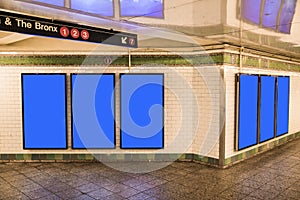 advertisement billboards electronic displays in a subway station in New York City.