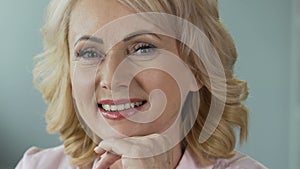 Advertising of anti-age cosmetics. Attractive mature woman smiling into camera