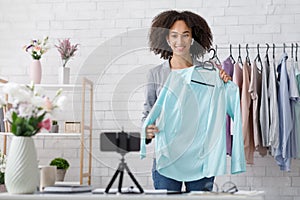 Advertising new collection in blog of modern fasion and working from home. Smiling african american lady with wireless