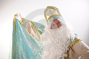 long cloak Saint Nicholas lifted with one hand and wrapped like a superman Sinterklaas portrait USA on a white