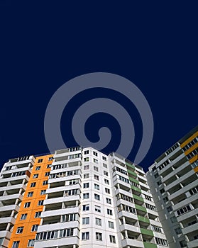 Advertising template of apartment sale and rental property. New multicolor residential building on dark blue background. Copy