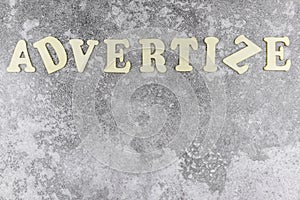 Advertize concept with offset alphabet letters on textured grey background