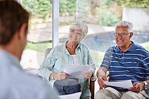 Advice for the good life. Over-the-shoulder shot of a financial advisor meeting with a senior couple at their home.