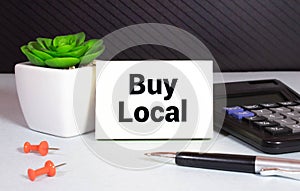 Advice to Buy Local printed on a brown paper price tag as a means of supporting local suppliers and producers.