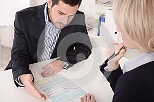 Adviser sitting in a meeting with a blank on the table explaining something. photo