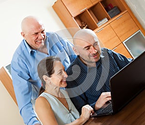 Advisor near mature couple with laptop