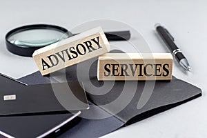 ADVISORY SERVICES text on wooden block on black notebook , business concept