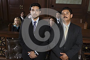 Advocate Standing With Client In Courtroom photo
