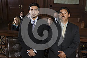 Advocate Standing With Client In Courtroom