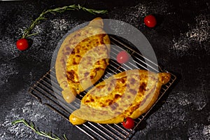 Adzharian khachapuri on a grill on a crispy surface with tomatoes