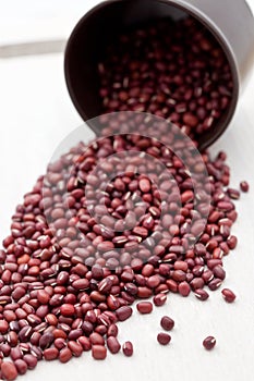 Adzuki beans pouring out of a brown cup