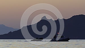 In the Aegean Sea, a coast guard boat tows another boat.