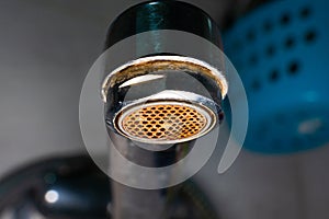 aerator diffuser in the faucet close-up. Corrosion and scale deposits from water. Dirty old water faucet in the washbasin on a