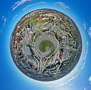 Aerial 360 angle panoramic little planet view on roundabout junction in medium city with traffic
