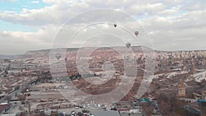 Aerial 4k drone footage of hot air balloons over the desert landscape of Cappadocia, Turkey.