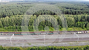 Aerial 4K fly over railway tracks with an empty cargo wagons in summer at sunset