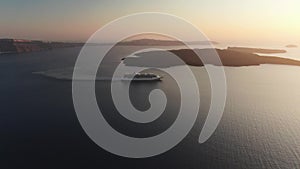 Aerial 4k Footage Cruise ship leaving the port Santorini in the sunset