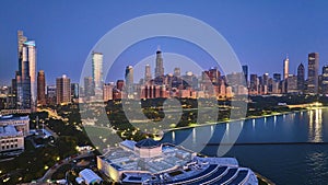 Aerial above aquarium with city lights at night reflection on Lake Michigan harbor water, Chicago IL