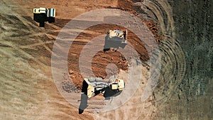 Aerial above shot of Excavator loads sand into mining truck. Mining Excavator loads sand rock into haul truck