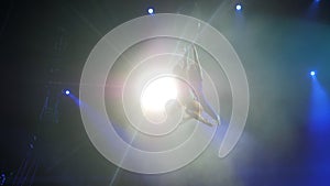 Aerial acrobat on the circus stage. A young girl and a guy perform acrobatic elements on the air ring, in the circus