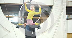 Aerial acrobatics by a man and woman doing a split on a hoop, circus, 4k