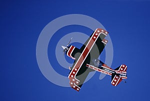 A pilot in a small Pitts bi-plane performs aerial acrobatics