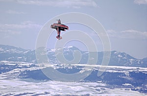 A pilot in a small Pitts bi-plane performs aerial acrobatics