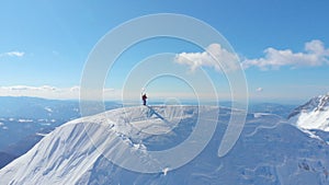 AERIAL: Active male tourist enjoying the stunning sights of snowy mountain range