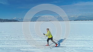 AERIAL: Active woman enjoying the winter by cross country skiing in Slovenia.