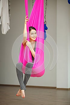 Aerial antigravity yoga concept, relaxed smiling girl in hammock