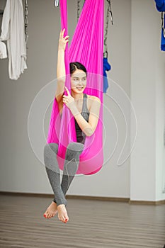 Aerial antigravity yoga concept, relaxed smiling girl in hammock