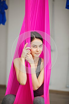 Aerial antigravity yoga concept, relaxed smiling girl in hammock