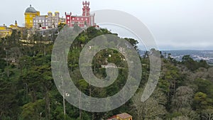 Aerial around view of Pena Palace Palacio da Pena in Sintra, Portugal. The palace is UNESCO World Heritage Site, shot from drone